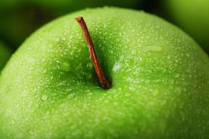 Juicy Green apple close-up with dew drops. photo