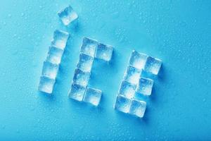 la palabra hielo es un patrón de cubitos de hielo sobre un fondo azul. foto