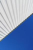 Geometry of a white corrugated metal building against a blue sky. photo