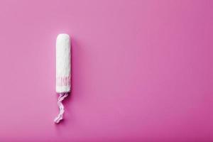 Hygienic tampon on a pink background with a free space photo