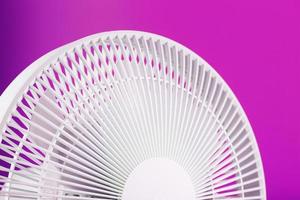 ventilador eléctrico en blanco con un diseño moderno para refrescar la habitación sobre un fondo rosa. foto