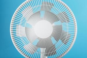 Electric fan in white with a modern design for cooling the room on a blue background photo