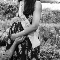 pareja india posando para una sesión de fotos de maternidad. la pareja está posando en un césped con hierba verde y la mujer está faluntando su panza en el jardín de lodhi en nueva delhi, india - blanco y negro