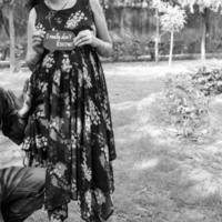 pareja india posando para una sesión de fotos de maternidad. la pareja está posando en un césped con hierba verde y la mujer está faluntando su panza en el jardín de lodhi en nueva delhi, india - blanco y negro