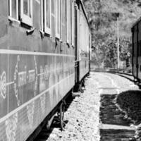 tren de juguete moviéndose en la ladera de la montaña, hermosa vista, montaña de un lado, valle de un lado moviéndose en ferrocarril a la colina, entre bosques naturales verdes.tren de juguete de kalka a shimla en india-blanco y negro foto