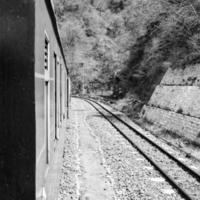 tren de juguete moviéndose en la ladera de la montaña, hermosa vista, montaña de un lado, valle de un lado moviéndose en ferrocarril a la colina, entre bosques naturales verdes.tren de juguete de kalka a shimla en india-blanco y negro foto