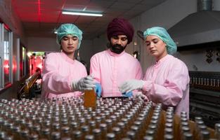 Product quality control staff at the fruit juice production line Perform product quality checks To ensure that the products produced are of good quality photo