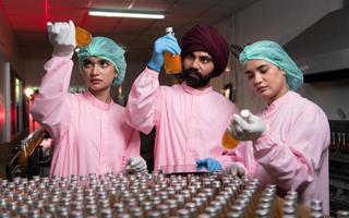 Product quality control staff at the fruit juice production line Perform product quality checks To ensure that the products produced are of good quality photo