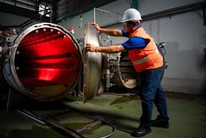 Engineer of the Mechanical Plant Conduct inspection of the sterilization machine tunnel. To check the working condition of the machine to be ready photo