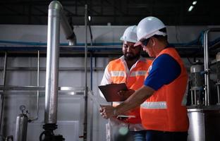 Chief engineer of a mechanical plant Inspecting and explaining the maintenance of the machine to the mechanic photo