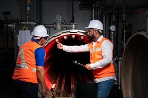 Chief engineer of a mechanical plant Inspecting and explaining the maintenance of the machine to the mechanic photo