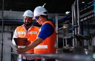 Chief engineer of a mechanical plant Inspecting and explaining the maintenance of the machine to the mechanic photo
