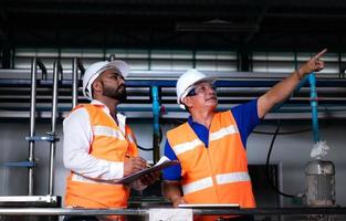 Chief engineer of a mechanical plant Inspecting and explaining the maintenance of the machine to the mechanic photo