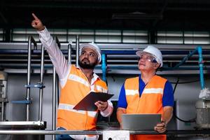 Chief engineer of a mechanical plant Inspecting and explaining the maintenance of the machine to the mechanic photo