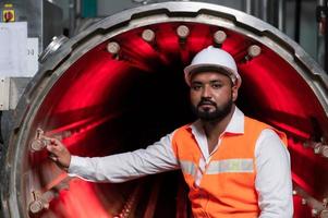 el ingeniero jefe de la planta mecánica realiza la inspección del túnel de la máquina de esterilización. para comprobar el estado de funcionamiento de la máquina para estar listo foto