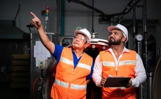 Chief engineer of a mechanical plant Inspecting and explaining the maintenance of the machine to the mechanic photo