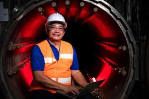 ingeniero de la planta mecánica realiza la inspección del túnel de la máquina de esterilización. para comprobar el estado de funcionamiento de la máquina para estar listo foto