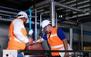 Chief engineer of a mechanical plant Inspecting and explaining the maintenance of the machine to the mechanic photo