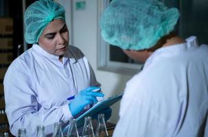 Product quality control officer in fruit juice production line Carry out an inspection of bottles used to contain fruit juices photo