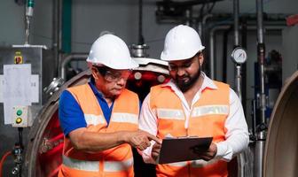 Chief engineer of a mechanical plant Inspecting and explaining the maintenance of the machine to the mechanic photo