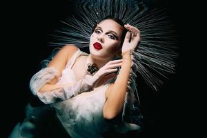 Beautiful woman with red lips and in women's jewellery underwater as the Virgin Mary photo