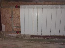 Installed metal heating radiators in the living room in the apartment photo
