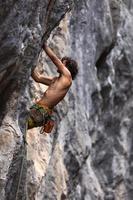 hombre fuerte escalando una roca. foto