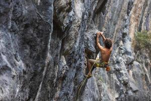 hombre fuerte escalando una roca. foto