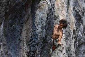 hombre fuerte escalando una roca. foto