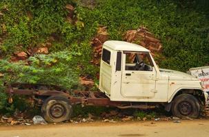 Broken old car is parked on the side of the road photo