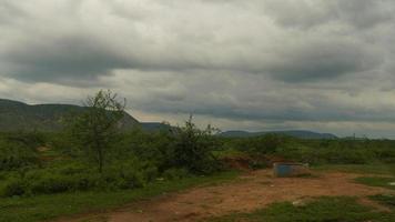 View of mountains and grass of Rajasthan with blue and white clouds photo