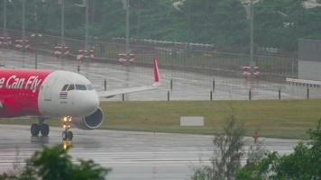 PHUKET, THAILAND DECEMBER 2, 2016 - Airbus 320 AirAsia HS BBH turn runway before departure on wet runway of Phuket airport. Rainy weather video
