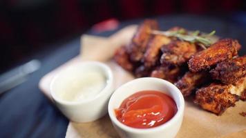 alitas de pollo fritas en un plato con diferentes salsas video