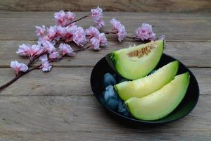 melon sliced with ice on wood background photo