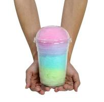 mano sujetando algodón de azúcar en un vaso de plástico aislado en fondo blanco,trazado de recorte foto