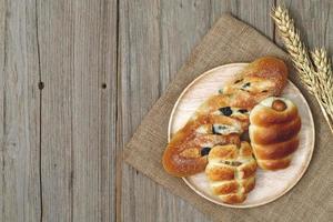 Sausage bread and wheat ears and sack on wooden background,top view photo