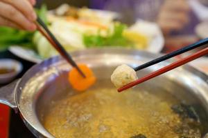 chopsticks holding meat ball in restaurant photo