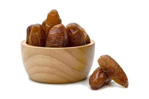 dry dates palm in wooden bowl isolated on white background. photo