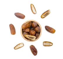 dry dates palm in wooden bowl isolated on white background. photo