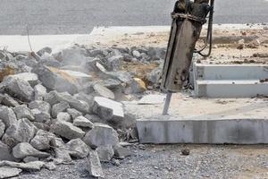 Breaking concrete with machine drilling or pneumatic hammer photo