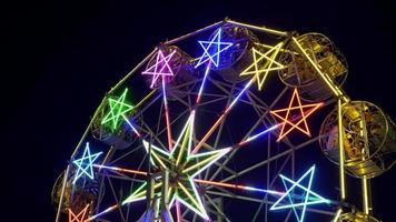 festival de roda gigante com luzes de neon brilhantes à noite na tailândia. 4k