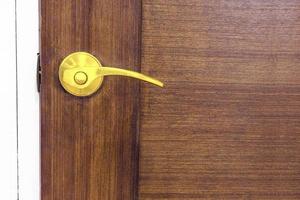 Golden door knob on wooden door photo