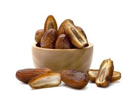 dry dates palm in wooden bowl isolated on white background. photo