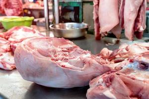 Carne de cerdo fresca en mesa de acero inoxidable en el mercado, Tailandia foto