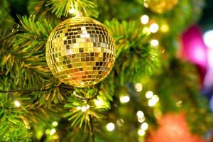 Closeup christmas tree and golden disco ball hanging of Christmas lights and New year photo