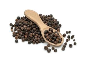 semillas de pimienta negra o granos de pimienta negra en una cuchara de madera aislada de fondo blanco foto