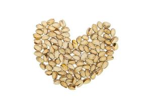 Closeup pistachios nut dry roasted and salted as heart shape isolated on white background photo