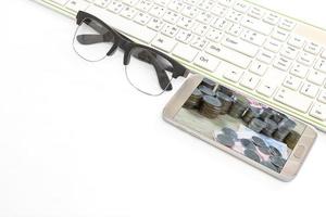 smart phone and keyboard and glasses on white background,business concept photo