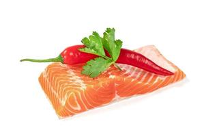 Piece of fresh salmon fillet sliced with coriander leaves and red pepper isolated on white background photo