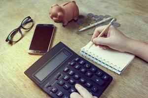 Human hand holding pencil with notepad on desk photo